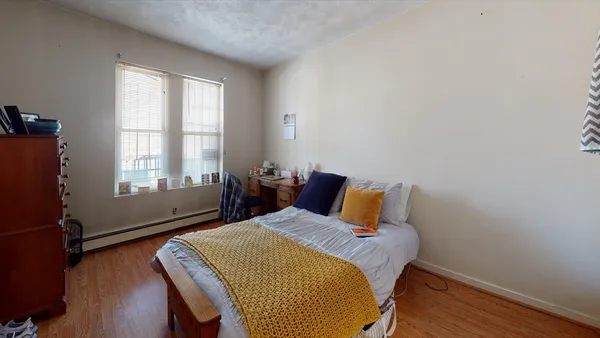 a bedroom with a bed and wooden floor