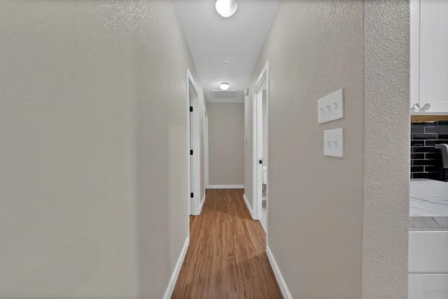 a view of a hallway with wooden floor