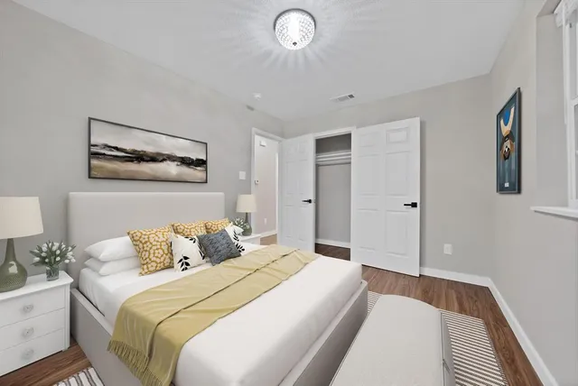 a bedroom with a bed and a lamp on dresser