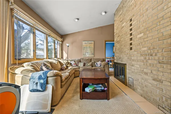 a living room with fireplace furniture and a floor to ceiling window