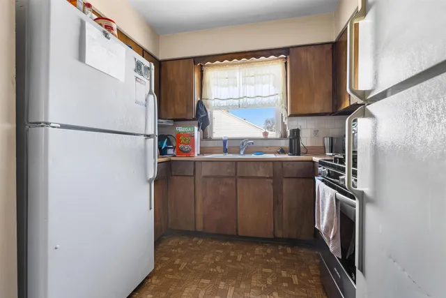a kitchen with a refrigerator a stove a sink and a window