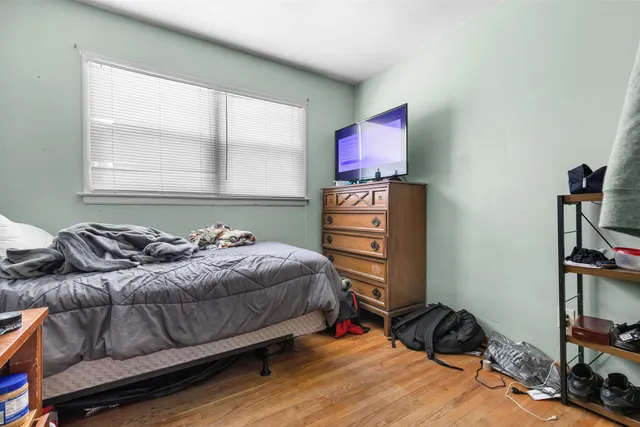a bedroom with a bed window and a flat screen tv