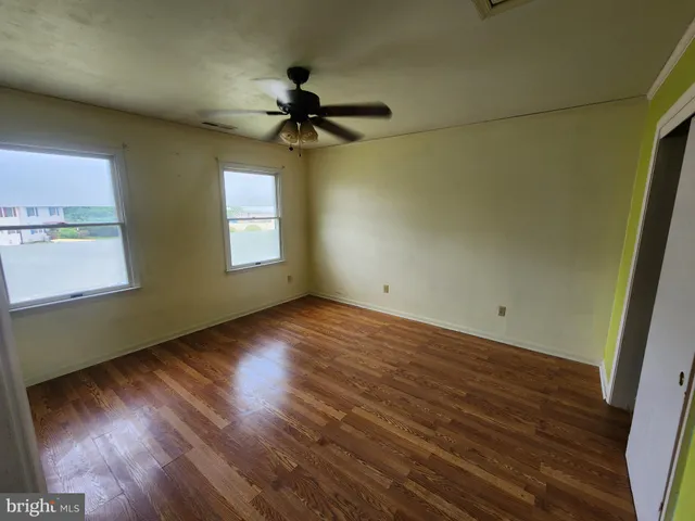 a view of an empty room with window and stairs
