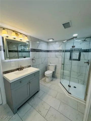 a bathroom with a sink toilet and shower