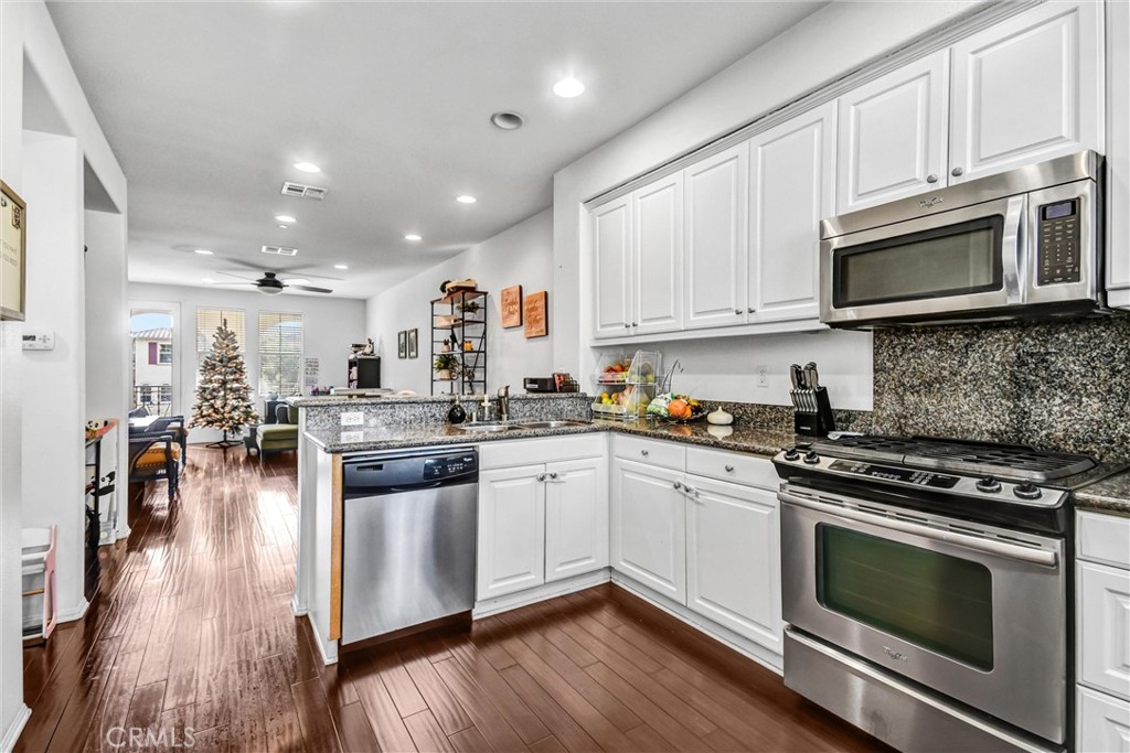 827 East Promenade, Unit E Azusa, CA 91702 - Photo 13 of 32 a kitchen with stainless steel appliances granite countertop a stove top oven a sink a counter space and cabinets