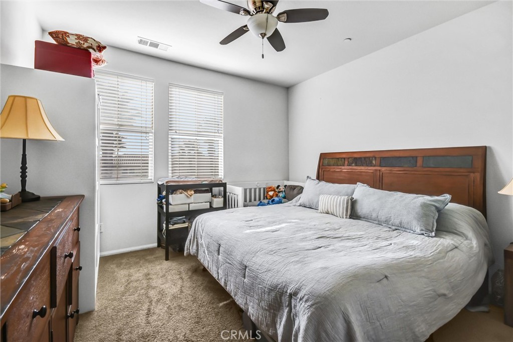 827 East Promenade, Unit E Azusa, CA 91702 - Photo 16 of 32 a bedroom with a bed and a chandelier