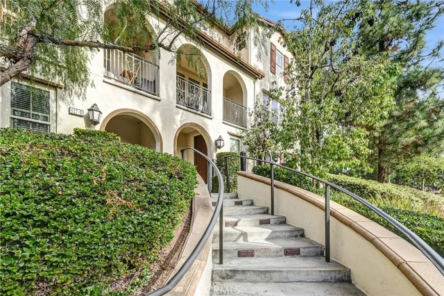 a view of a house with fountain and large trees