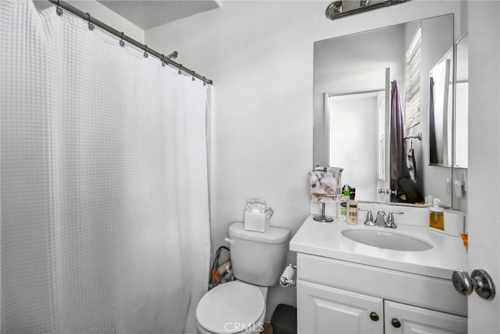 827 East Promenade, Unit E Azusa, CA 91702 - Photo 23 of 32 a bathroom with a toilet sink and mirror
