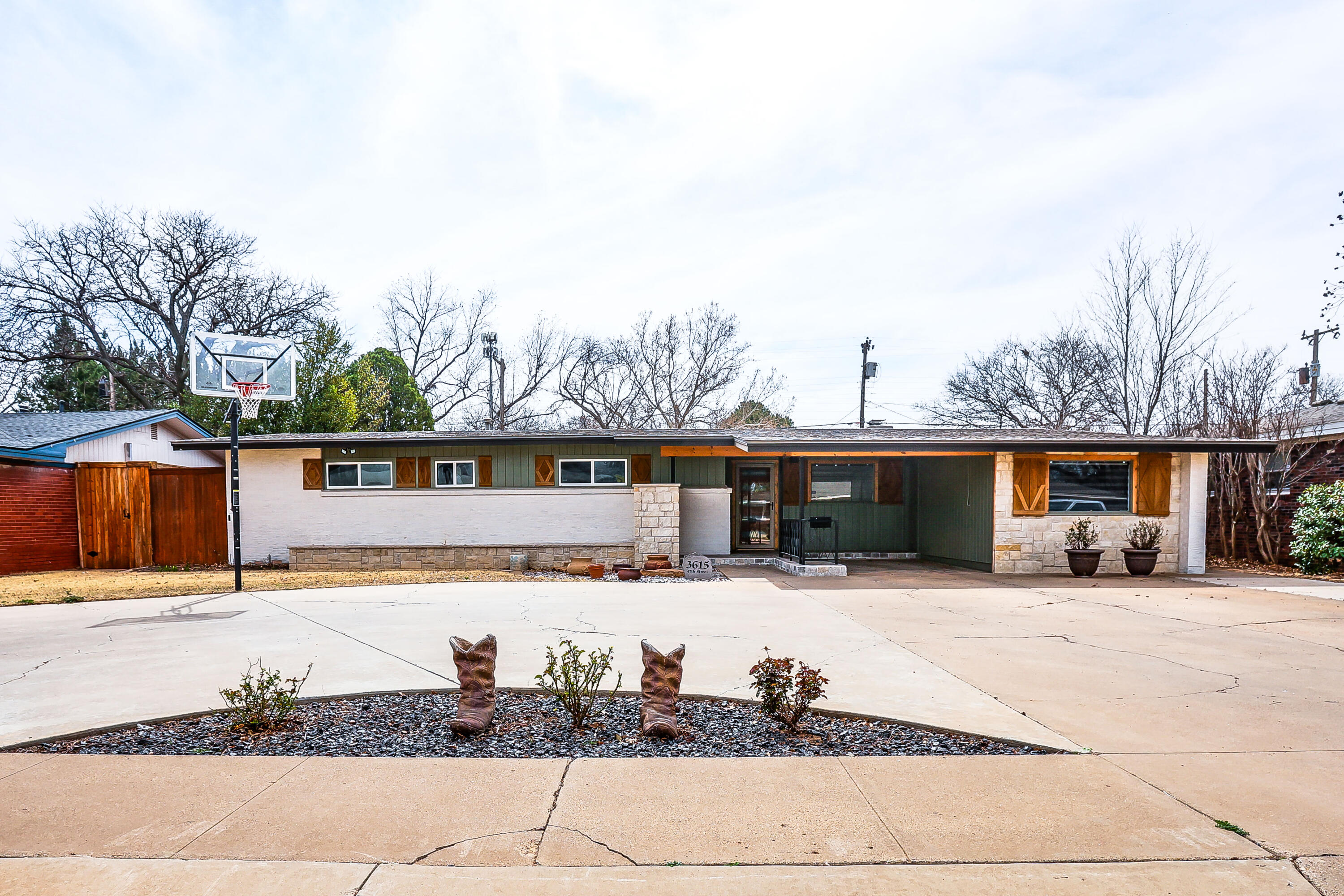 a front view of house with yard and trees in the background