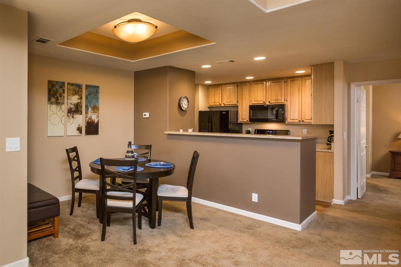 900 S, Unit 3114 Reno, NV 89521 - Photo 2 of 18 a kitchen with kitchen island a dining table chairs and a refrigerator