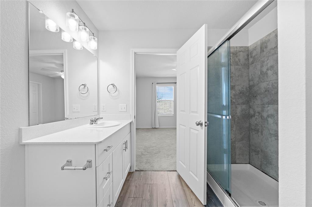 4432 Sagecroft Road Fort Worth, TX 76036 - Photo 8 of 16 Bathroom with vanity, a shower stall, and light wood-style floors