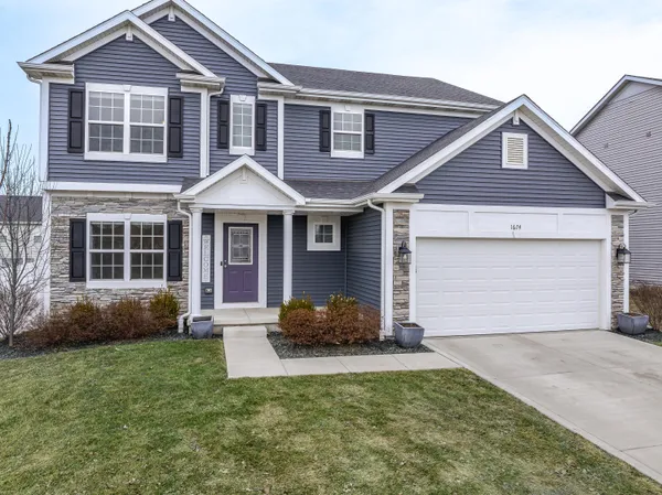 a front view of a house with a yard and garage
