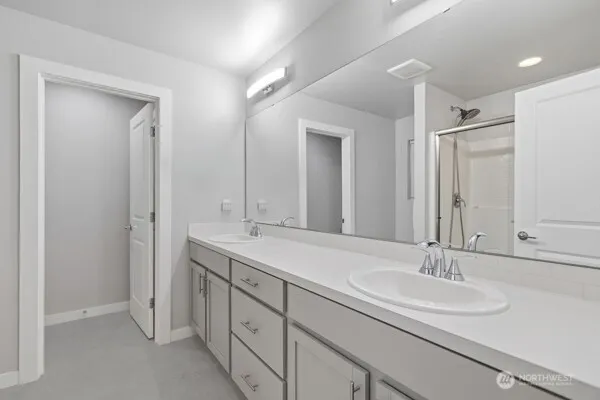 a bathroom with double sink and a mirror