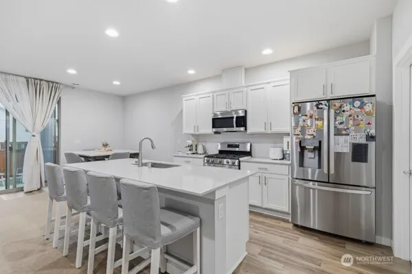 a kitchen with stainless steel appliances a refrigerator stove microwave and cabinets