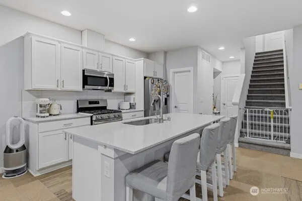 a kitchen with kitchen island a sink appliances and cabinets
