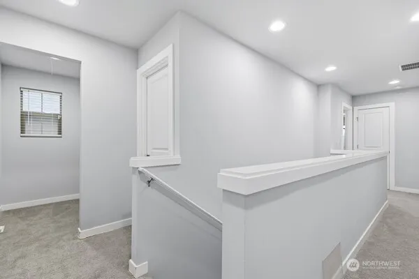 a room with wooden floor and white cabinets