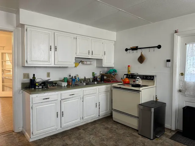 a kitchen with granite countertop white cabinets and white appliances