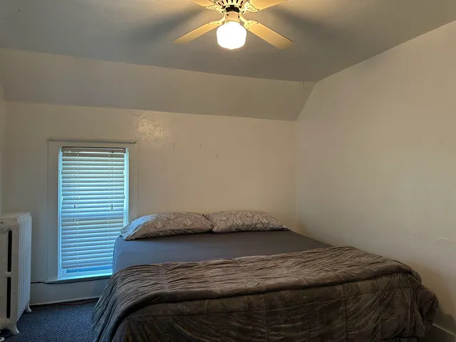 a bedroom with a bed and a window
