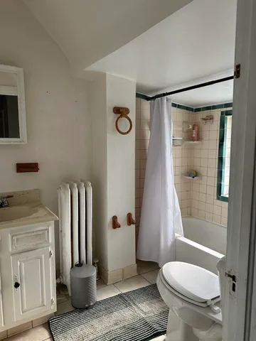 a bathroom with a granite countertop sink toilet and shower