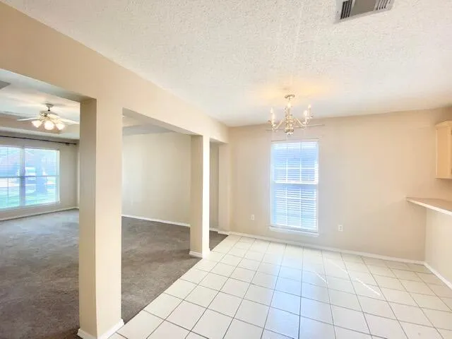 an empty room with windows and cabinet