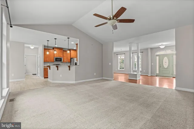 an empty room with ceiling fan and window