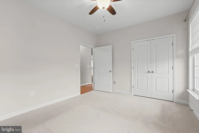 an empty room with closet and fan