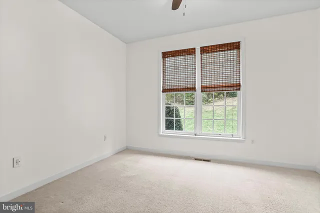 a spacious bathroom with a granite countertop sink a toilet and a mirror