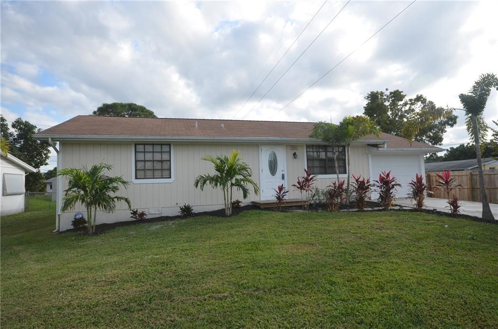 2444 Southeast Washington Street Stuart, FL 34997 - Photo 1 of 13 a front view of a house with a garden