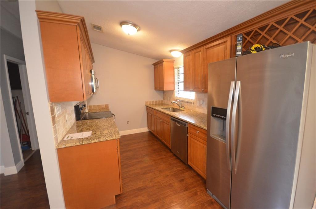 2444 Southeast Washington Street Stuart, FL 34997 - Photo 3 of 13 a kitchen with stainless steel appliances granite countertop a refrigerator and a sink