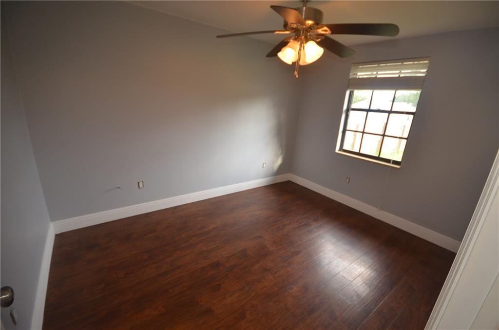 2444 Southeast Washington Street Stuart, FL 34997 - Photo 10 of 13 an empty room with wooden floor chandelier fan and windows