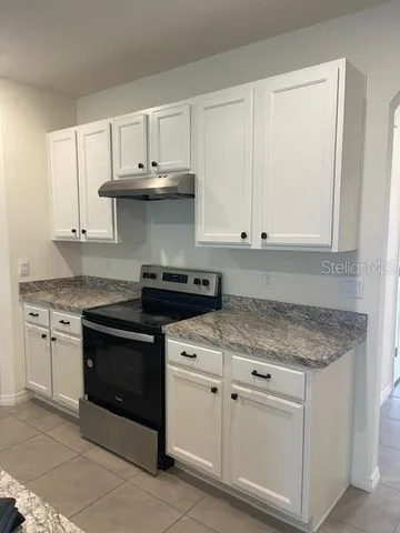 a kitchen with white cabinets and appliances