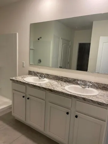 a bathroom with a granite countertop sink and a mirror
