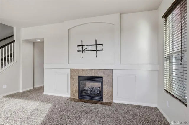 a view of an empty room with a fireplace and a window
