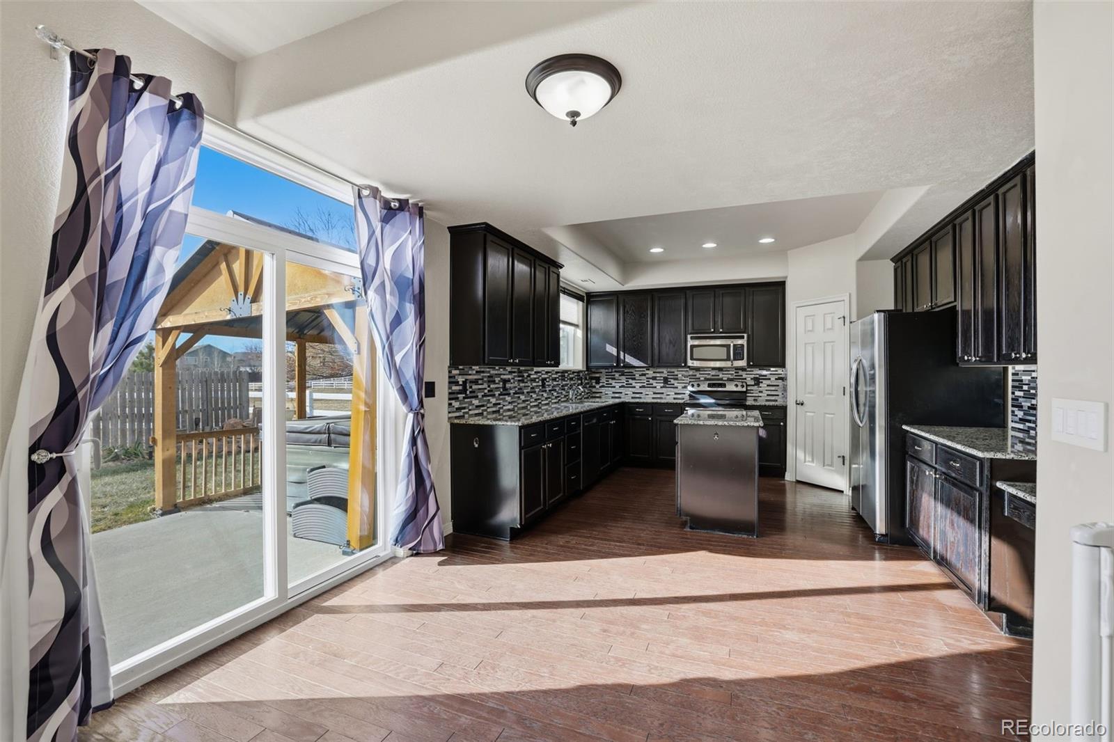 2224 Reed Grass Way Colorado Springs, CO 80915 - Photo 15 of 45 a kitchen with stainless steel appliances kitchen island granite countertop a refrigerator oven a sink and dishwasher