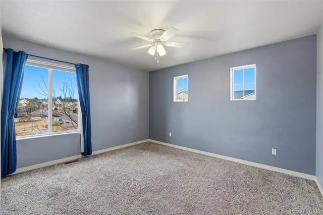 an empty room with closet and chandelier fan
