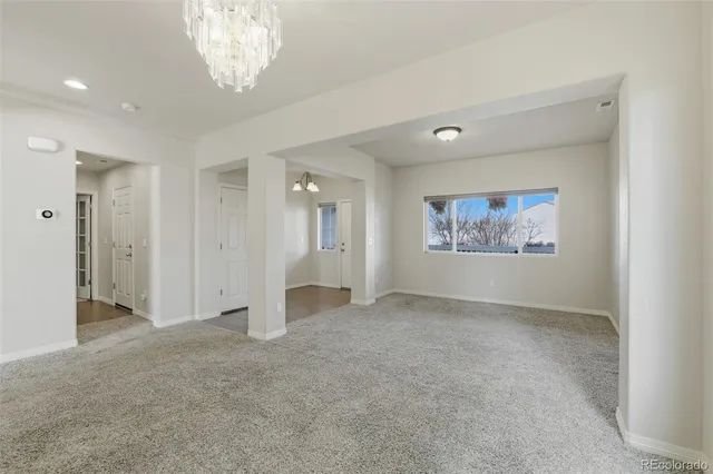 an empty room with chandelier fan