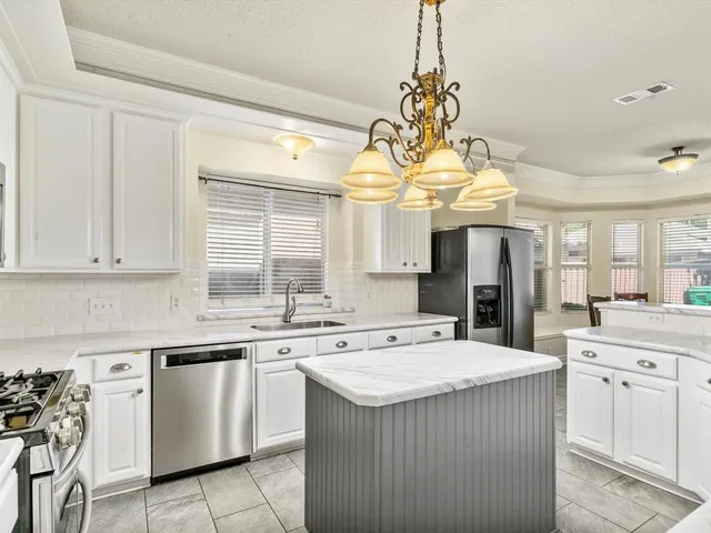 a kitchen with stainless steel appliances a sink stove and cabinets