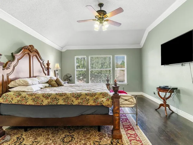 a bed sitting in a bedroom next to a window with pc on the table