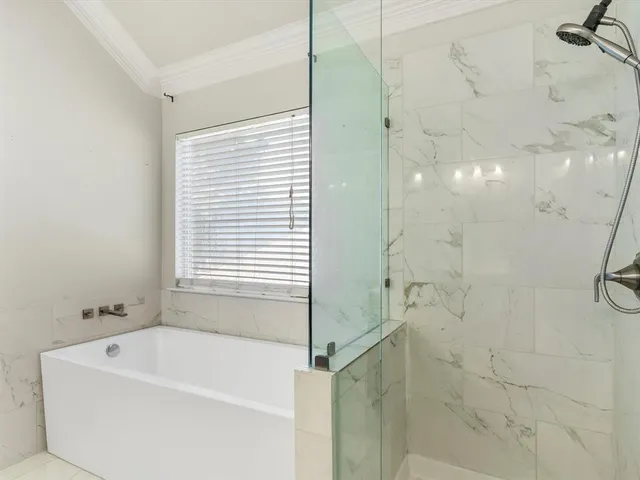 a spacious bathroom with a tub sink and mirror
