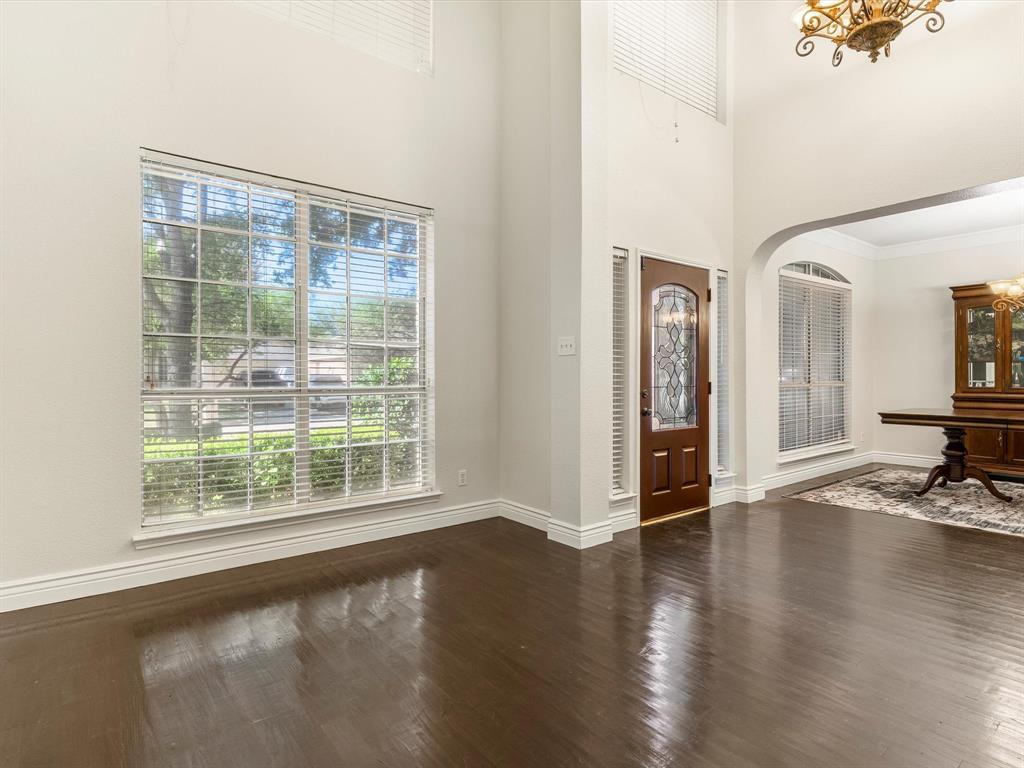 7121 Raintree Way Denton, TX 76210 - Photo 9 of 38 a view of an empty room with wooden floor and a window