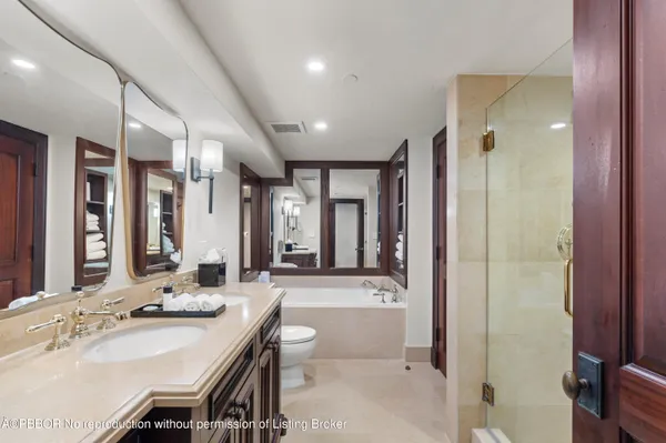 a bathroom with a granite countertop sink a toilet a mirror and shower