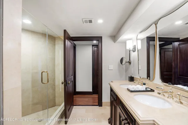 a bathroom with a double vanity sink mirror and shower