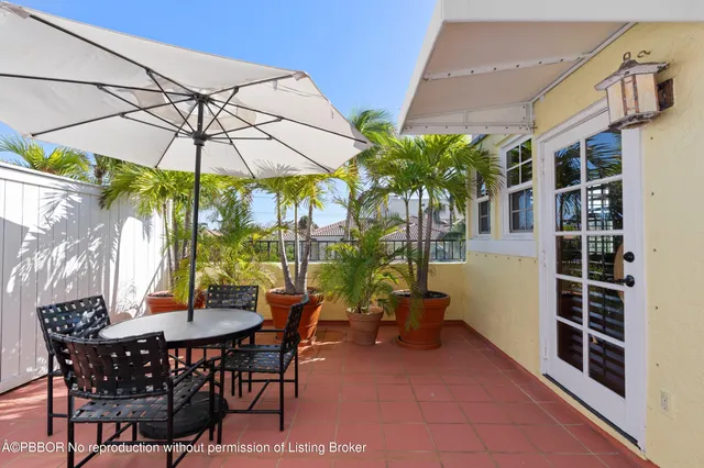 a view of a patio with a table and chairs under an umbrella