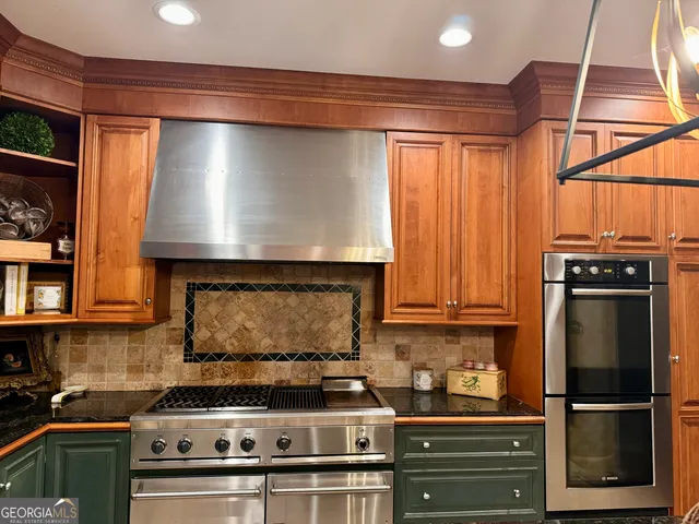 a kitchen with granite countertop a sink stainless steel appliances and cabinets