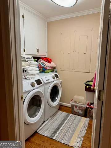 a view of a hallway with wooden floor and a bathroom