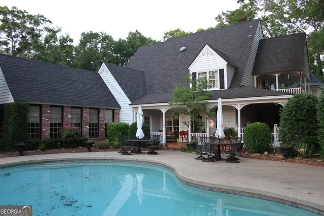 a view of house with outdoor space and swimming pool