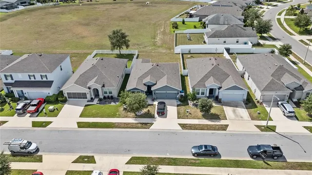 an aerial view of residential houses with outdoor space and parking