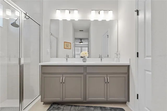 a bathroom with a double vanity sink mirror and shower