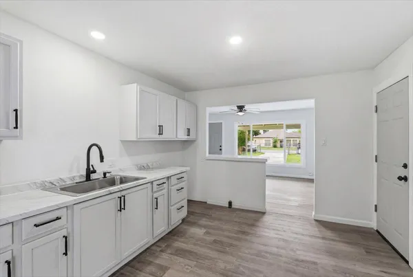 a kitchen with a sink cabinets and wooden floor