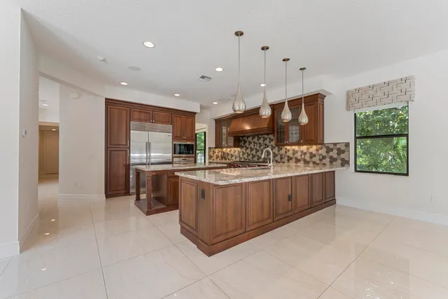 a view of an empty room with window and chandelier